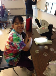 Lenora examines sand grains under the microscope