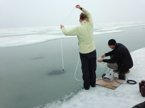 Tara and Dr. Jim McClelland collect water samples through a hole in the sea ice